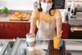 Bar owner giving takeaway orders to customer at her restaurant during corona virus outbreak - Young woman worker wearing face