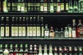 Bar shelf with a lot of different alcoholic drink bottles.