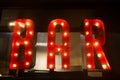 BAR sign with lights in the dark with many shapes of bottles of alcohol Royalty Free Stock Photo