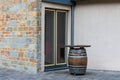 Bar table in the form of a wooden barrel in front of a glass door