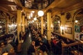 Bar visitors having dinner and drinks inside old style restaurant with vintage furniture