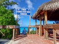 A bar where alcoholic beverages are served at the beach in Half Moon Cay, Bahamas and a sign that says Royalty Free Stock Photo