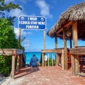 A bar where alcoholic beverages are served at the beach in Half Moon Cay, Bahamas and a sign that says Royalty Free Stock Photo
