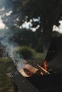 barbecue BBQ grill with flaming fire and ember charcoal on nature background, Flaming charcoal grill with open fire Royalty Free Stock Photo