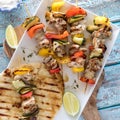 Barbecue chicken and veggie skewers served with grilled naan bread.