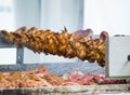 Barbecue chicken wings grilling in skewer machine.