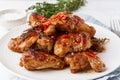 Barbecue chicken wings. Oven baked chiken on plate. Hot korean food. Side view, close up Royalty Free Stock Photo