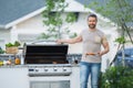 Barbecue concept. Middle aged hispanic man in t-shirt for barbecue. Roasting and grilling food. Roasting meat outdoors Royalty Free Stock Photo