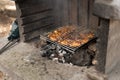 barbecue for cooking shish kebab with a grid of meat in a picnic park in forest, hot spring day Royalty Free Stock Photo