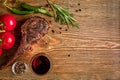 Barbecue dry aged rib of beef with vegetables and glass of red wine close-up on wooden background Royalty Free Stock Photo