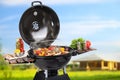Barbecue grill with meat products and vegetables on sunny day