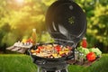 Barbecue grill with meat products and vegetables on sunny day, closeup Royalty Free Stock Photo