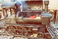 Barbecue grill with meat in shape of old steam locomotive, yellow filter