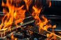 Barbecue grill pit with glowing and flaming hot open fire with red flame, hot charcoal briquettes and embers Royalty Free Stock Photo