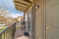 Barbecue grill on small balcony with roof overhang and huge window with shutters