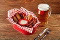 Barbecue grilled chicken wings close up with potatoes, sauce and beer on wooden background. Royalty Free Stock Photo