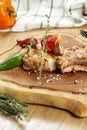 Barbecue grilled Pork Chop with hot pepper and tomato on a wooden board. CLose up. Selective focus
