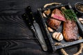 Barbecue Grilled rump cap or brazilian picanha beef meat steak in a wooden tray. Black wooden background. Top view. Copy space