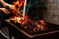 barbecue man fixes burning firewood in the barbecue in the yard