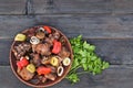 grilled meat with vegetables and herbs in a plate on the table. Royalty Free Stock Photo