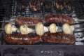 Barbecue on an open fire. Barbecue with firewood. Fried champignen, fatty and juicy sausages and toasted chicken legs. Yummy Royalty Free Stock Photo