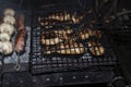 Barbecue on an open fire. Barbecue with firewood. Fried champignen, fatty and juicy sausages and toasted chicken legs. Yummy Royalty Free Stock Photo