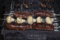 Barbecue on an open fire. Barbecue with firewood. Fried champignen, fatty and juicy sausages and toasted chicken legs. Yummy Royalty Free Stock Photo