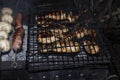 Barbecue on an open fire. Barbecue with firewood. Fried champignen, fatty and juicy sausages and toasted chicken legs. Yummy Royalty Free Stock Photo