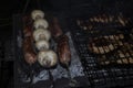 Barbecue on an open fire. Barbecue with firewood. Fried champignen, fatty and juicy sausages and toasted chicken legs. Yummy Royalty Free Stock Photo