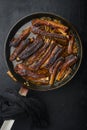 Barbecue pork spare ribs with fruit relish, in frying cast iron pan, on black stone background, top view flat lay Royalty Free Stock Photo