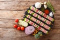 For barbecue raw shish kebab with pepper and lard on skewers close-up and ingredients, vegetables, spices, herbs. Horizontal top Royalty Free Stock Photo