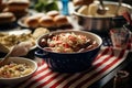 A barbecue ribboned with garlands of red, white and blue ribbon, hot dogs and hamburgers cooking on the grill, next to a bowl of Royalty Free Stock Photo