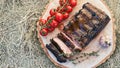 Barbecue ribs meat prepared in traditional European style with rosemary herb cherry tomatoes and garlic on a raw solid