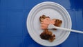 Barbecue with sauce in a plastic disposable dish on a blue plastic table Royalty Free Stock Photo