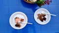 Barbecue with sauce in a plastic disposable dish on a blue plastic table Royalty Free Stock Photo