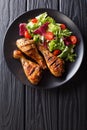 Barbecue serving of grilled chicken drumsticks and fresh vegetable salad closeup. Vertical top view