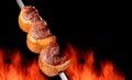 Barbecued Picanha barbecue with blurred fire in the background. Brazilian churrasco or churrascaria.