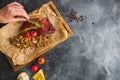 Barbecued ribs, buckwheat with mushroom and tomatoes on wooden cutting board and female hand. Food and background. Flat lay. Top v Royalty Free Stock Photo