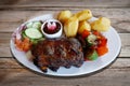 Barbecued spareribs with tomatoes and salad Royalty Free Stock Photo