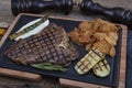 Barbecued t-bone steak seasoned with fresh herbs and marinade served with a cutting board in a steakhouse. Delicious restaurant Royalty Free Stock Photo