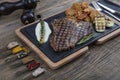 Barbecued t-bone steak seasoned with fresh herbs and marinade served with a cutting board in a steakhouse. Delicious restaurant