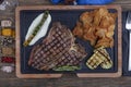 Barbecued t-bone steak seasoned with fresh herbs and marinade served with a cutting board in a steakhouse. Delicious restaurant