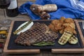 Barbecued t-bone steak seasoned with fresh herbs and marinade served with a cutting board in a steakhouse. Delicious restaurant Royalty Free Stock Photo