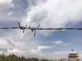 Barbed wire against blue sky and defocused building