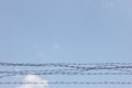 Barbed Wire Against Blue Sky Symbolizing Restriction and Security Royalty Free Stock Photo