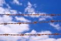 Barbed wire against cloudy sky