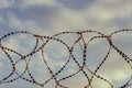 Barbed wire against the sky with clouds. The prohibition of air travel Royalty Free Stock Photo