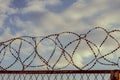 Barbed wire against the sky with clouds. The prohibition of air travel Royalty Free Stock Photo