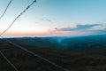 Barbed wire on the background of the sunrise in the mountains. Early morning purple blue