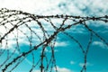Barbed wire. Barbed wire on blue sky background with white clouds. Wire boom. Military conflict . Syria. Royalty Free Stock Photo